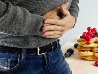 homme qui a mal au ventre devant des pancakes